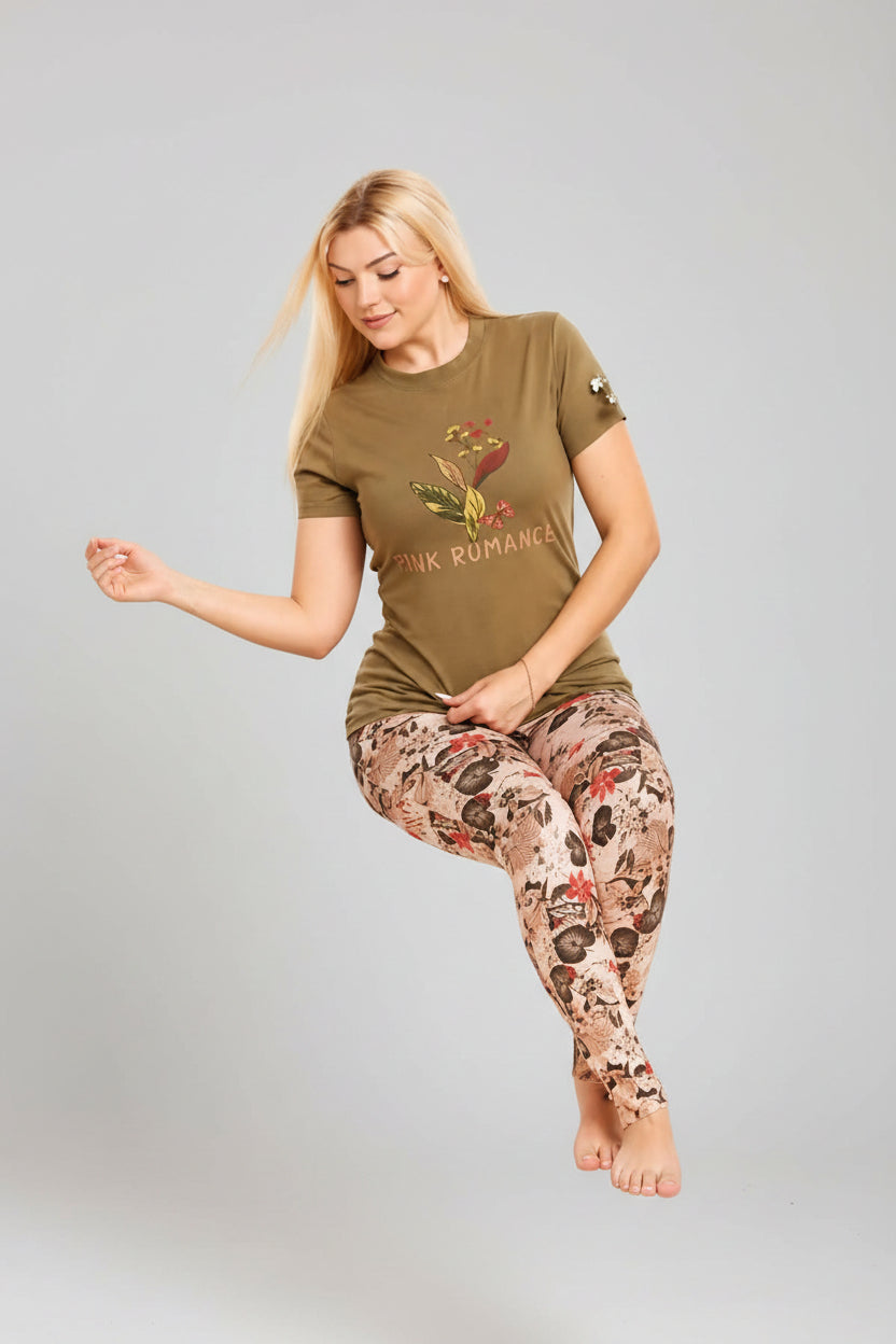 Woman sitting on a chair wearing a green t-shirt and patterned leggings, with 'väura' branding.