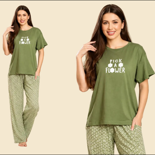 Woman wearing a green 'Pick a Flower' pajama set in a living room setting.