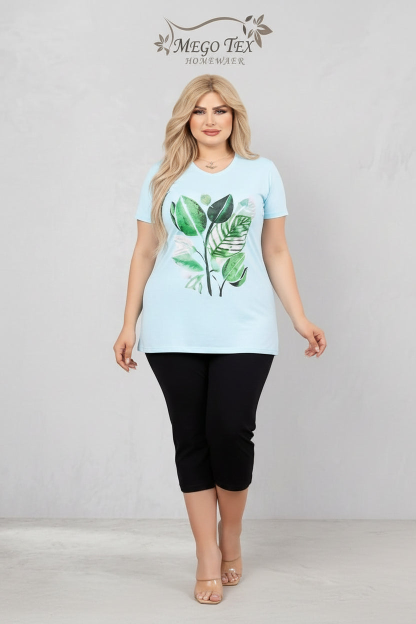 Woman wearing a light blue t-shirt with a leaf design, standing next to a mirror reflection and a small table with a phone.