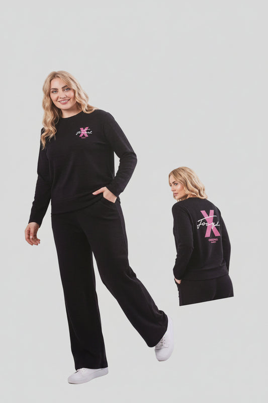 Woman wearing a black outfit with a pink logo, standing next to a promotional board for the brand 'Fox Yan'.
