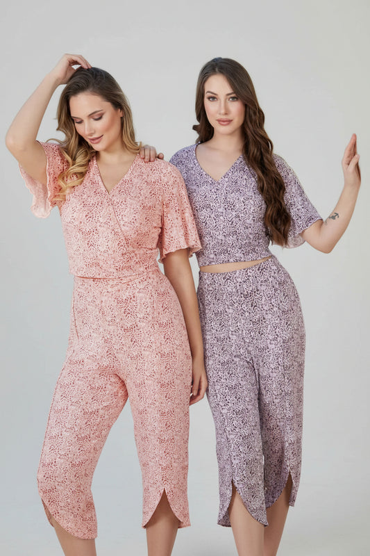 Two women wearing floral outfits by a poolside with 'Hassan's Home Fashion' branding.
