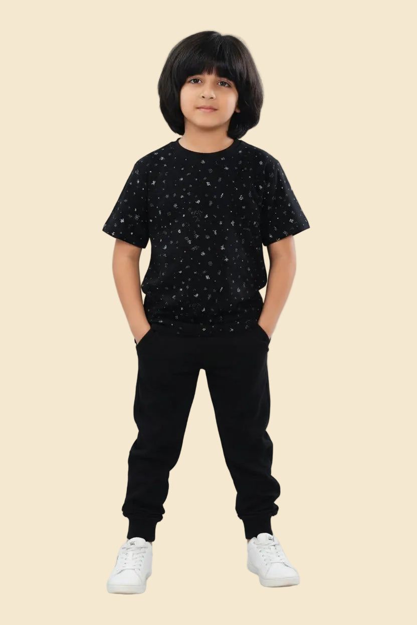 Child wearing a black star-patterned t-shirt and black pants with a Zara logo in the corner.