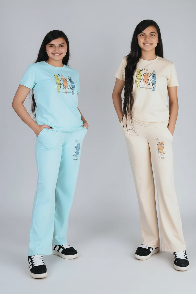 Two young girls wearing matching outfits with text and numbers on a wooden floor.