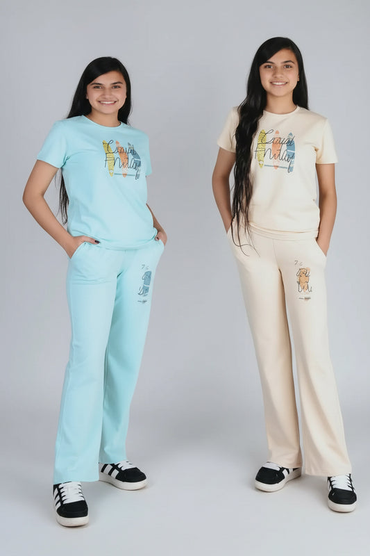 Two young girls wearing matching outfits with text and numbers on a wooden floor.